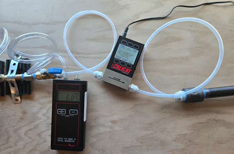 LaRovere Consulting lab test setup — Alicat flow meter and Dwyer digital manometer measuring pipe leakage